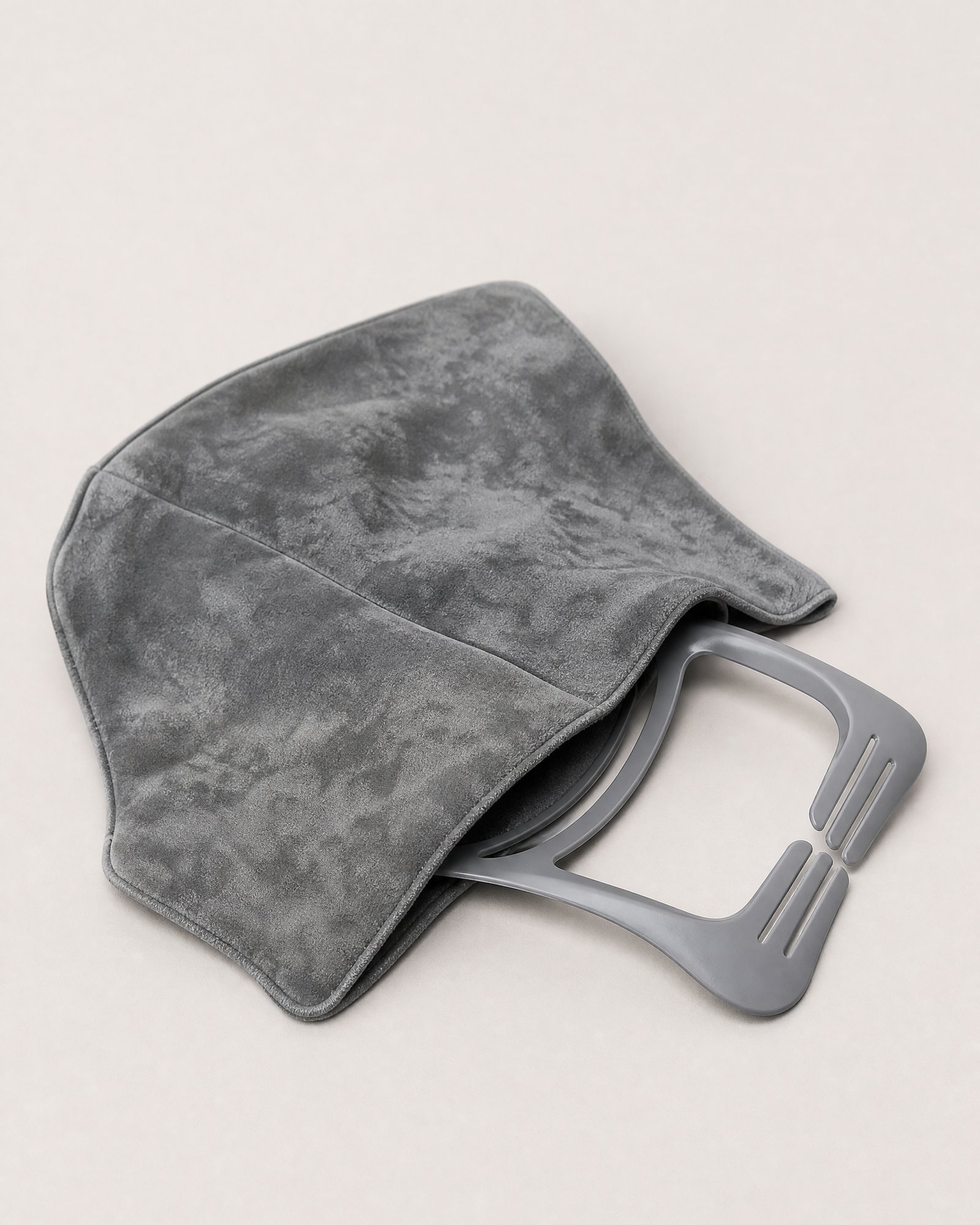 The grey NODD Travel Pillow opened, with its flexible support frame slid halfway out of the fleece