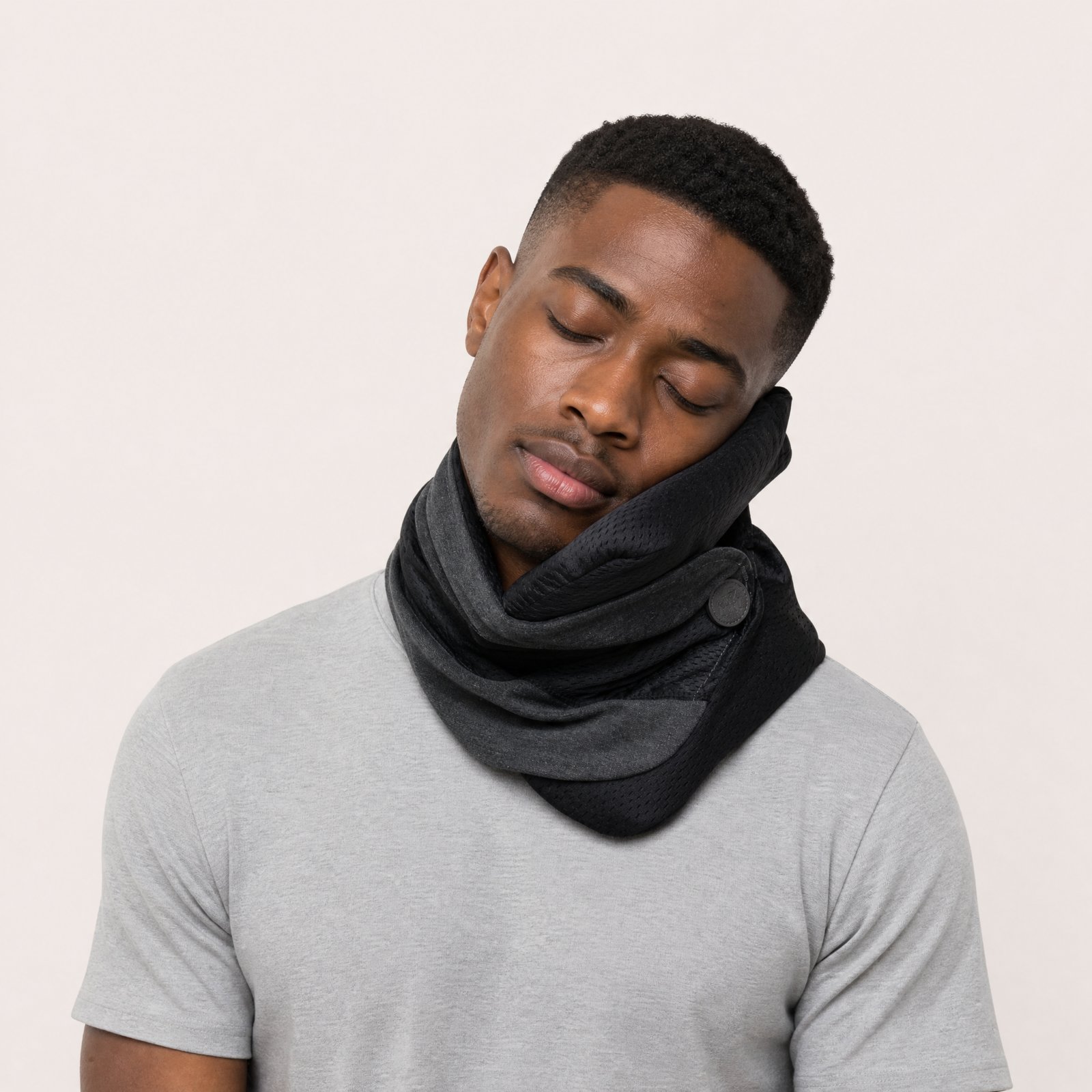 A man resting his head on the black NODD Pillow Cool